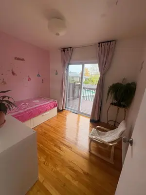 a bedroom with a bed and a window with a balcony at Escapade familiale à Longueuil in Longueuil