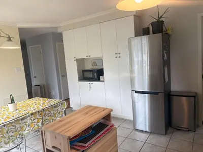 a kitchen with a stainless steel refrigerator and a table at Escapade familiale à Longueuil in Longueuil