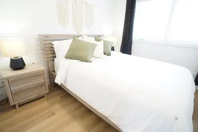 a bedroom with a white bed and a night stand at Loup in Magog-Orford