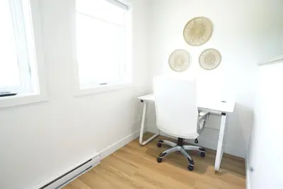 a white desk and chair in a room with windows at Loup in Magog-Orford