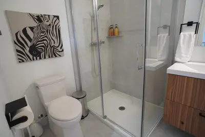 a bathroom with a shower and a toilet and a picture of a zebra at Loup in Magog-Orford