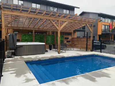 a patio with a swimming pool and a wooden pergola at Loup in Magog-Orford