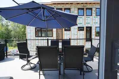 a table with chairs and an umbrella on a patio at Loup in Magog-Orford