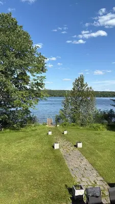a group of benches on the grass near a body of water at Havre du lac magog in Sainte-Catherine-de-Hatley