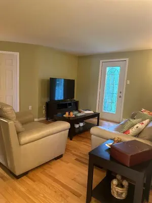 a living room with two couches and a tv at Havre du lac magog in Sainte-Catherine-de-Hatley