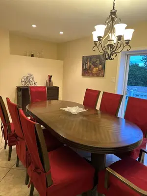 a dining room with a wooden table and red chairs at Havre du lac magog in Sainte-Catherine-de-Hatley