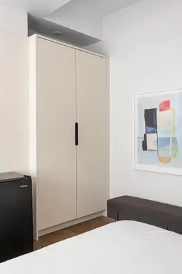a bedroom with a white cabinet and a painting at Nomade Saint Paul in Montréal