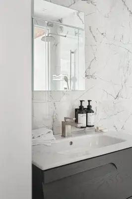 a white bathroom with a sink and a mirror at Nomade Saint Paul in Montréal