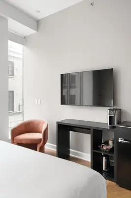 a bedroom with a bed and a desk and a chair at Nomade Saint Paul in Montréal