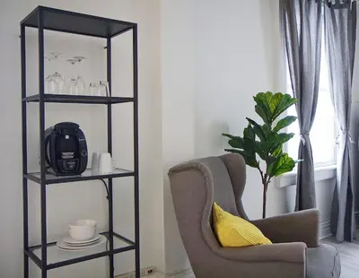a living room with a chair and a mirror at Gite La Cache in Beloeil Village