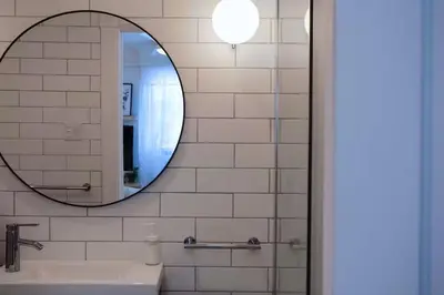 a bathroom with a mirror and a sink at Gite La Cache in Beloeil Village