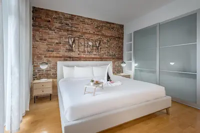 a bedroom with a white bed and a brick wall at Charming Family Escape in Trendy Plateau Montreal in Montréal