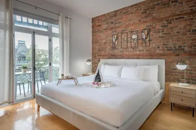 a large white bed in a room with a brick wall at Charming Family Escape in Trendy Plateau Montreal in Montréal