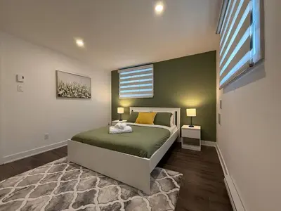 a bedroom with a bed and a window at Beautiful Spacious 4BR with Parking, Near Montreal in Longueuil