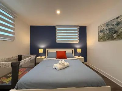 a bedroom with a bed and a red pillow at Beautiful Spacious 4BR with Parking, Near Montreal in Longueuil