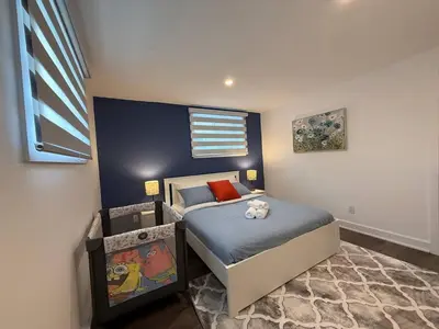 a bedroom with a bed with a blue wall at Beautiful Spacious 4BR with Parking, Near Montreal in Longueuil
