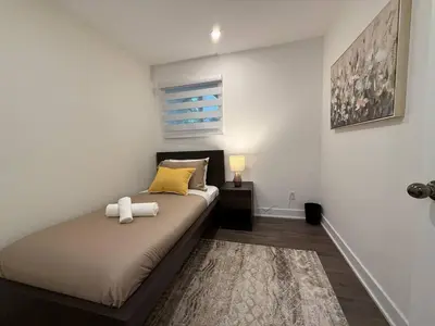 a bedroom with a bed with a yellow pillow at Beautiful Spacious 4BR with Parking, Near Montreal in Longueuil