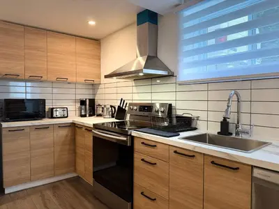 a kitchen with a sink and a stove top oven at Beautiful Spacious 4BR with Parking, Near Montreal in Longueuil