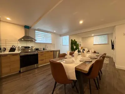 a kitchen with a table and chairs in a room at Beautiful Spacious 4BR with Parking, Near Montreal in Longueuil