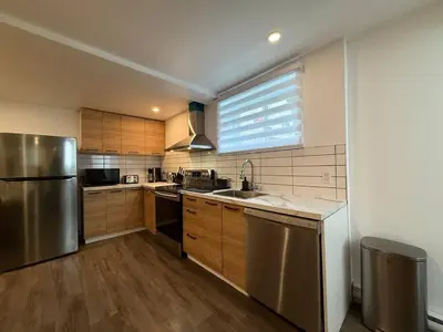 a kitchen with stainless steel appliances and a window at Beautiful Spacious 4BR with Parking, Near Montreal in Longueuil