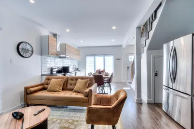 a living room with a couch and a kitchen at Modern Comforts 3 Bedroom & Full Kitchen & Wifi & Easy Montreal Access in Longueuil