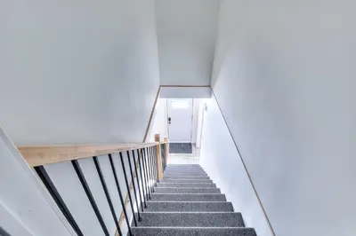 a staircase in a house with a white wall at Modern Comforts 3 Bedroom & Full Kitchen & Wifi & Easy Montreal Access in Longueuil