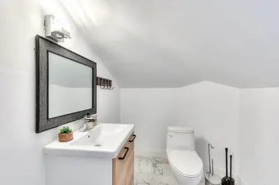 a white bathroom with a sink and a mirror at Modern Comforts 3 Bedroom & Full Kitchen & Wifi & Easy Montreal Access in Longueuil