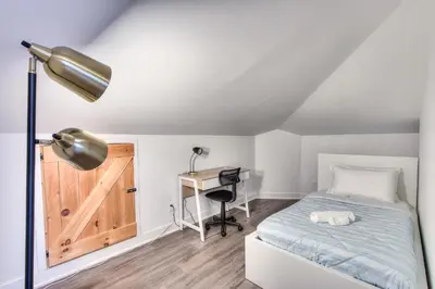 a bedroom with a bed and a desk with a lamp at Modern Comforts 3 Bedroom & Full Kitchen & Wifi & Easy Montreal Access in Longueuil