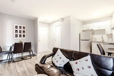 a living room with a leather couch and a kitchen at Charmant 1-chambre proche restaurants et attractions in Montréal