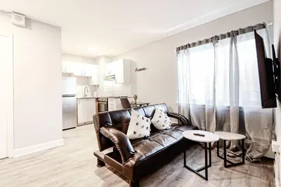 a living room with a leather couch and a table at Charmant 1-chambre proche restaurants et attractions in Montréal