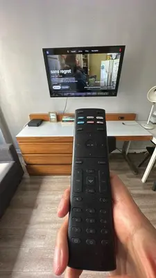 a hand holding a remote control in front of a tv at Guy Concordia! Nightlife! Downtown's Essentials! Best City Spot! in Montréal