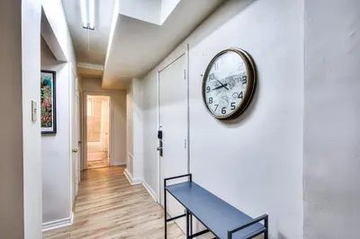 a clock on a wall with a blue bench in a hallway at Cute & Cozy Hub for Montreal Travelers in Montréal