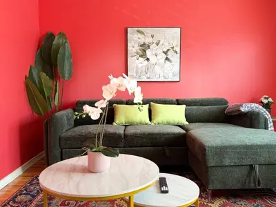 a living room with a couch and a red wall at Cute & Cozy Hub for Montreal Travelers in Montréal