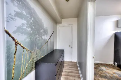 a room with a balcony with a large painting on the wall at Cute & Cozy Hub for Montreal Travelers in Montréal