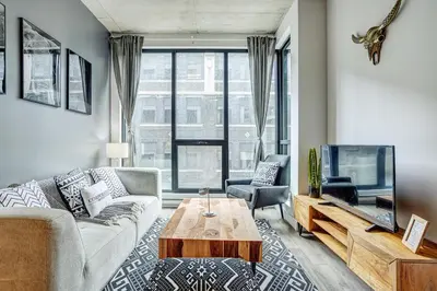 a living room with a couch and a tv at Montreal - C Lofts Le Smith - 2B1B 1006 in Montréal