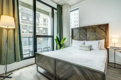 a bedroom with a bed and a large window at Montreal - C Lofts Le Smith - 2B1B 1006 in Montréal