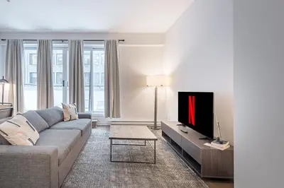 a living room with a couch and a flat screen tv at Historic Old Montreal Stay - Iconic Location in Montréal