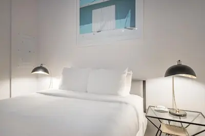 a bedroom with a white bed and two lamps at Historic Old Montreal Stay - Iconic Location in Montréal