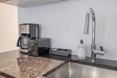 a kitchen counter with a coffee maker and a microwave at Historic Old Montreal Stay - Iconic Location in Montréal