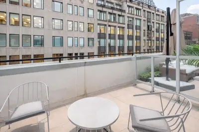 a balcony with a table and chairs and a building at Historic Old Montreal Stay - Iconic Location in Montréal