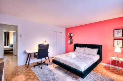 a bedroom with a bed and a desk in it at Beautiful and Cozy 3BR in Montreal West Island in Montréal