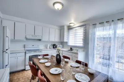 a kitchen with a wooden table with chairs and a dining room at Beautiful and Cozy 3BR in Montreal West Island in Montréal