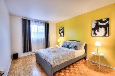 a bedroom with a bed and a yellow wall at Beautiful and Cozy 3BR in Montreal West Island in Montréal
