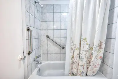 a bathroom with a shower curtain and a tub at Beautiful and Cozy 3BR in Montreal West Island in Montréal