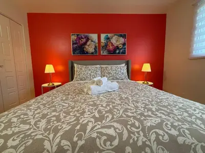 a bedroom with a large bed with red walls at Beautiful and Cozy 3BR in Montreal West Island in Montréal