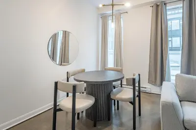 a dining room with a table and chairs and a mirror at Chic Old Montreal Retreat - Iconic Location in Montréal