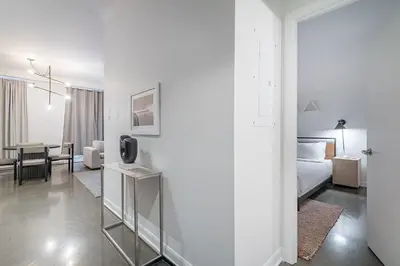 a white room with a bed and a living room at Chic Old Montreal Retreat - Iconic Location in Montréal