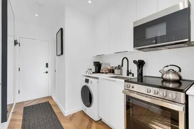 a kitchen with a stove and a washer and dryer at The Speakeasy Suite 503 With Parking in Montréal