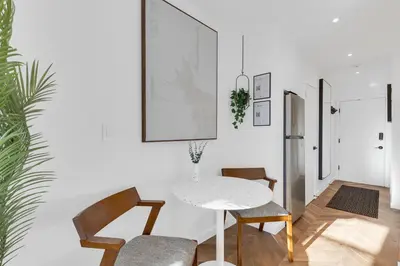 a dining room with a white table and chairs at The Speakeasy Suite 503 With Parking in Montréal