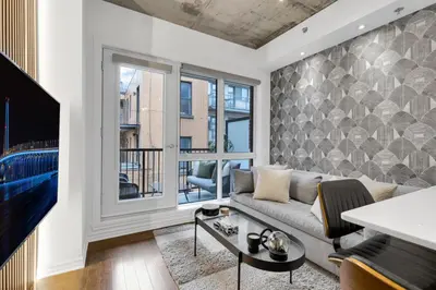 a living room with a couch and a tv at Flat at the Foot of the Mountain With Parking in Montréal